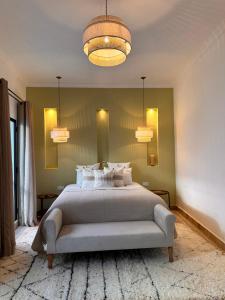 a bedroom with a large bed and two chandeliers at Riad Belharra in Marrakech +51 photos