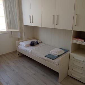 een klein bed in een kamer met witte kasten bij Cielo Mare in Viareggio