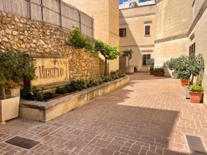 a building with a sign on the side of it at Inzolia - Peaceful Villa with Pool in Il-Pergla