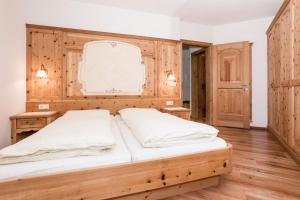 a bedroom with a large bed with wooden walls at Leishof in Villandro