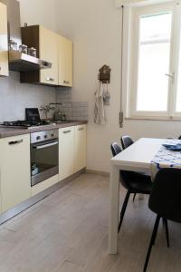 een keuken met witte kasten en een tafel met stoelen bij Cielo Mare in Viareggio