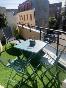 d'une table et de deux chaises sur un balcon. dans l'établissement Cocon douillet résidence calme, à Pau