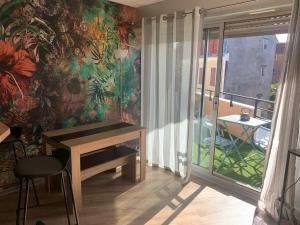 a room with a desk and a wall with a mural at Cocon douillet résidence calme in Pau