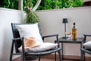een hoed op een stoel naast een tafel met een fles wijn bij Villa B&B Marina & Parking Free in Rovinj
