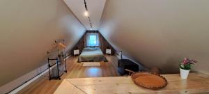 a attic room with a bed and a table at ORYNKA chatka w Malinnikach in Malinniki