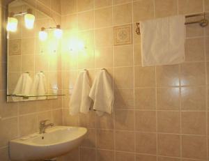 a bathroom with a sink and a mirror and towels at Avra Hotel in Tinos