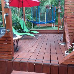een terras met een schommel en een paraplu bij Green Apple Guesthouse in Leányfalu