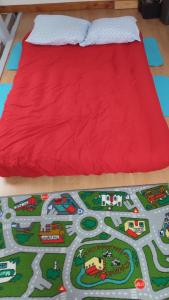 - un lit avec un couvre-lit rouge au dernier étage dans l'établissement Magnifique maison à 5 mns du circuit des 24h à pieds, au Mans