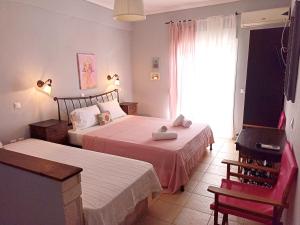 a bedroom with two beds and a chair and a window at Fani House in Kallithea Halkidikis
