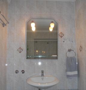 a bathroom with a sink and a mirror at Avra Hotel in Tinos