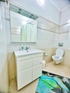 a bathroom with a white sink and a toilet at Апартаменты в центре в ЖК МАНХЕТТЕН in Almaty