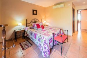 VillamielにあるRestaurante & Casa Rural Boadaのベッドルーム1室(ベッド1台、赤い椅子付)