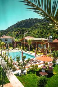 a resort with a pool and a mountain in the background at Cirali Hestia Lodge in Kemer