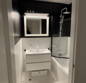 W łazience znajduje się biała umywalka i lustro. w obiekcie Duże mieszkanie blisko plaży w Gdańsku