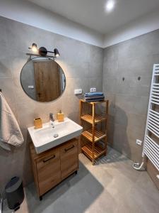 een badkamer met een wastafel en een spiegel bij Apartmán Kašperák in Kašperské Hory