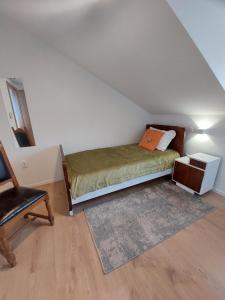 a bedroom with a bed and a chair in a attic at Apartmani Elisa in Stari Grad