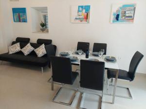 une salle à manger avec une table blanche et des chaises noires dans l'établissement Orange Tree House, à Šipanska Luka