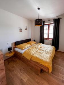 a bedroom with a large bed with a yellow bedspread at Apartmán Kašperák in Kašperské Hory