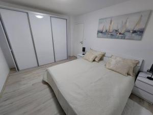 a bedroom with a large white bed and large windows at Orange Tree House in Šipanska Luka