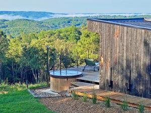 a wooden deck with a table and a bench on a house at Hameau Du Sentier Des Sources in Sarlat-la-Canéda