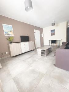 - un salon avec un canapé et une télévision dans l'établissement L'Hermitage - Appartement T3 en bord de plage, à Filaos
