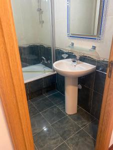 a bathroom with a sink and a mirror and a tub at Rocas Brancas in Ribadeo
