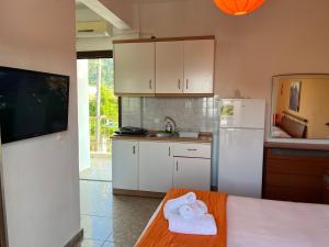 a kitchen with white cabinets and a white refrigerator at Apartment & Studios Haido in Vourvourou