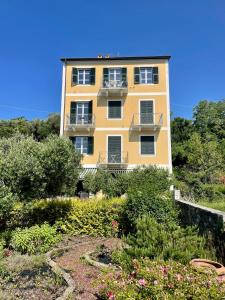 a yellow building with a lot of bushes and flowers at My Place Your Place in Corniglia
