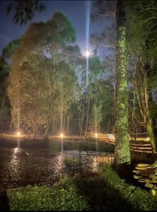 um parque à noite com um lago e luzes em Cabana Paradouro da Serra em Cambará