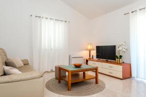 a living room with a couch and a tv at Apartman Enzzo in Šibenik