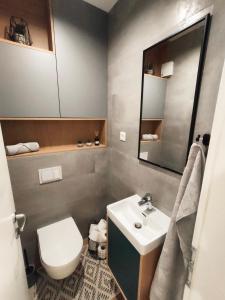 een badkamer met een wastafel, een toilet en een spiegel bij Naria in Podstrana