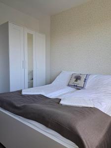 Una cama blanca con una almohada encima. en Levander Apartman, en Balatonföldvár