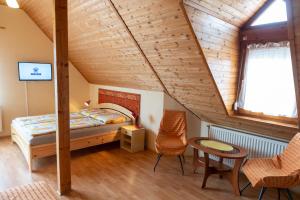 バラトンフレドにあるHuszár Vendégházのベッドルーム1室(ベッド1台、テーブル、椅子付)