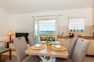 a kitchen and dining room with a wooden table and chairs at Apartman Enzzo in Šibenik