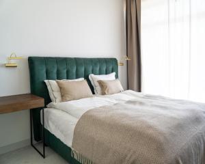 的住宿－Vila MonRai，一张带绿色床头板的床,靠窗