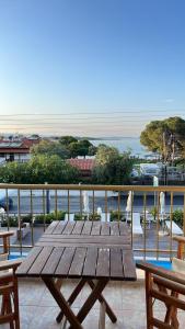 una mesa de madera en un balcón con vistas al océano en Apartment & Studios Haido, en Vourvourou