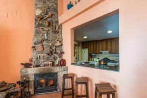 a living room with a fireplace and two stools at Restaurante & Casa Rural Boada in Villamiel