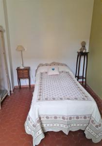 a bedroom with a bed with a white comforter at La maison de Toinette in Arles