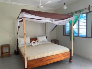 Summer Beach Paje في باجي: غرفة نوم مع سرير بطابقين مع مظلة