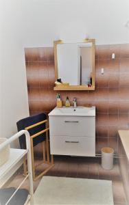 y baño con lavabo blanco y espejo. en La maison de Toinette en Arles