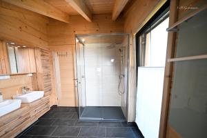 ein Bad mit einer Dusche und einem Waschbecken in der Unterkunft Holzwies Chalets in Unterneukirchen