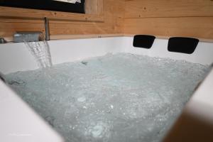 eine mit Wasser gefüllte Badewanne in einem Zimmer in der Unterkunft Holzwies Chalets in Unterneukirchen