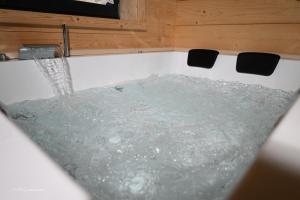 a bath tub filled with water in a room at Holzwies Chalets in Unterneukirchen