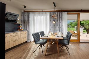 una cucina con tavolo in legno con sedie e una sala da pranzo di Maximilian Appartements a Schwangau