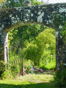 an old stone archway with a bike in the grass at Johnby Hall in Penrith