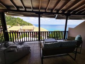 balcón con sofá y vistas al océano en The Ionian View, en Agios Nikitas
