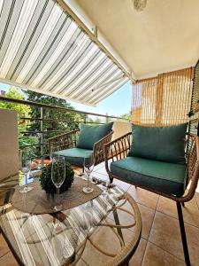 einen Balkon mit 2 Stühlen und einem Tisch mit Weingläsern in der Unterkunft Adriatic Rhapsody in Novalja