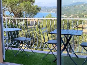 un tavolo e sedie su un balcone con vista sull'oceano di Agréable appartement vue mer a Les Issambres