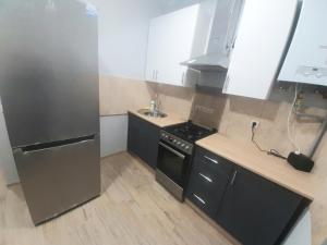 eine Küche mit einem Kühlschrank aus Edelstahl und einer Spüle in der Unterkunft Apart Pro in Uschhorod
