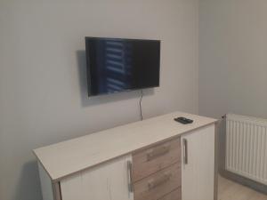escritorio con TV de pantalla plana en la pared en Apart Pro en Úzhgorod